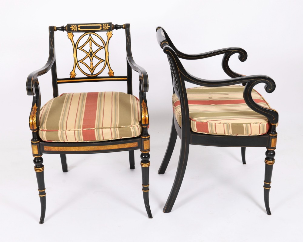 A set of ten ebonised and parcel-gilt Regency Revival dining chairs featuring pierced splat backs and striped upholstered seats. View II