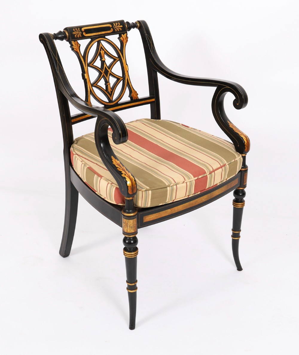 A set of ten ebonised and parcel-gilt Regency Revival dining chairs featuring pierced splat backs and striped upholstered seats. View III