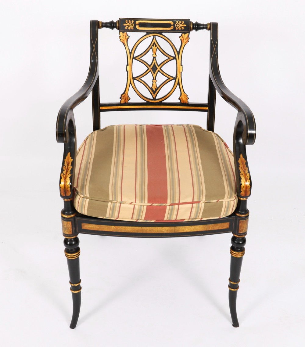 A set of ten ebonised and parcel-gilt Regency Revival dining chairs featuring pierced splat backs and striped upholstered seats. View IV