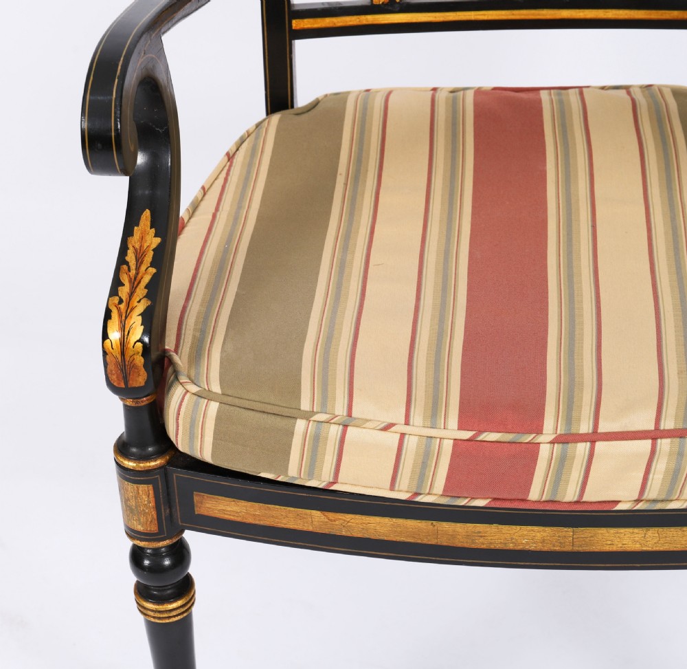 A set of ten ebonised and parcel-gilt Regency Revival dining chairs featuring pierced splat backs and striped upholstered seats. View VI