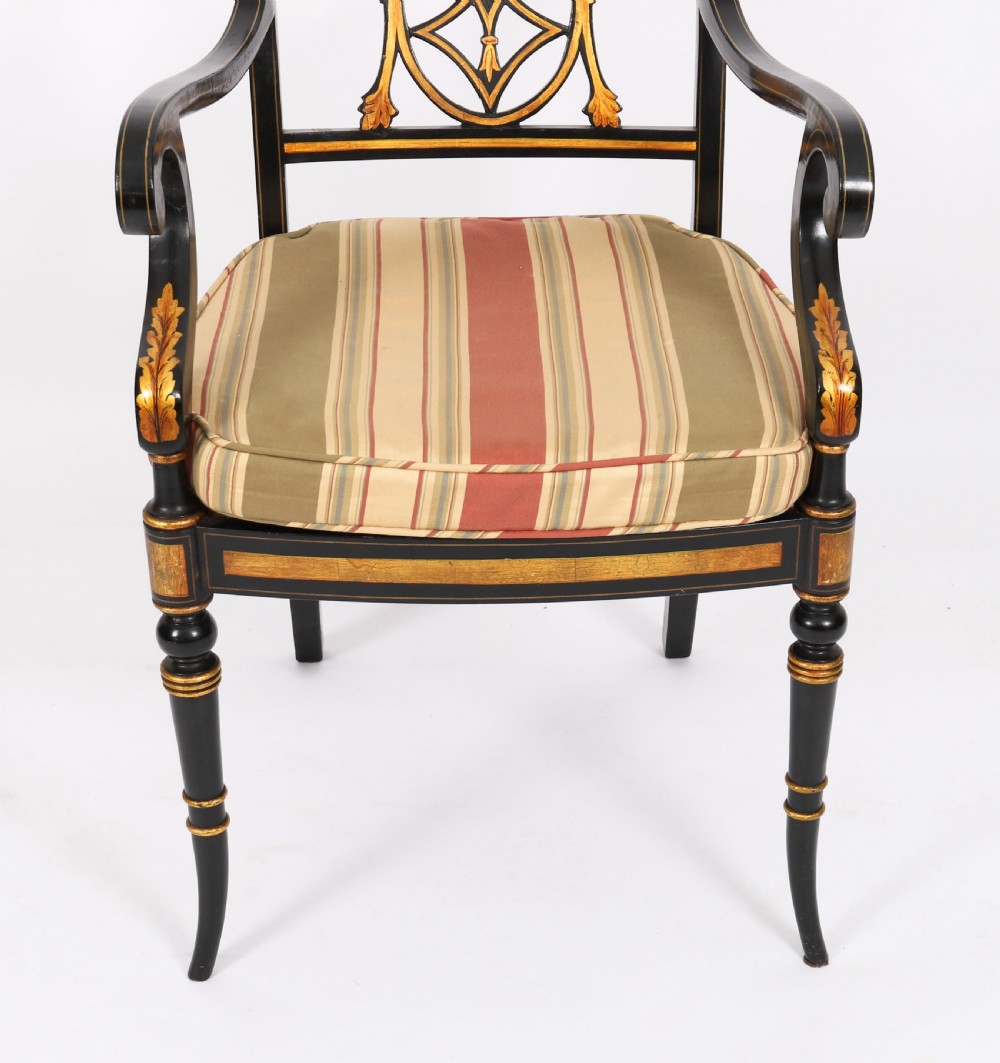 A set of ten ebonised and parcel-gilt Regency Revival dining chairs featuring pierced splat backs and striped upholstered seats. View VII