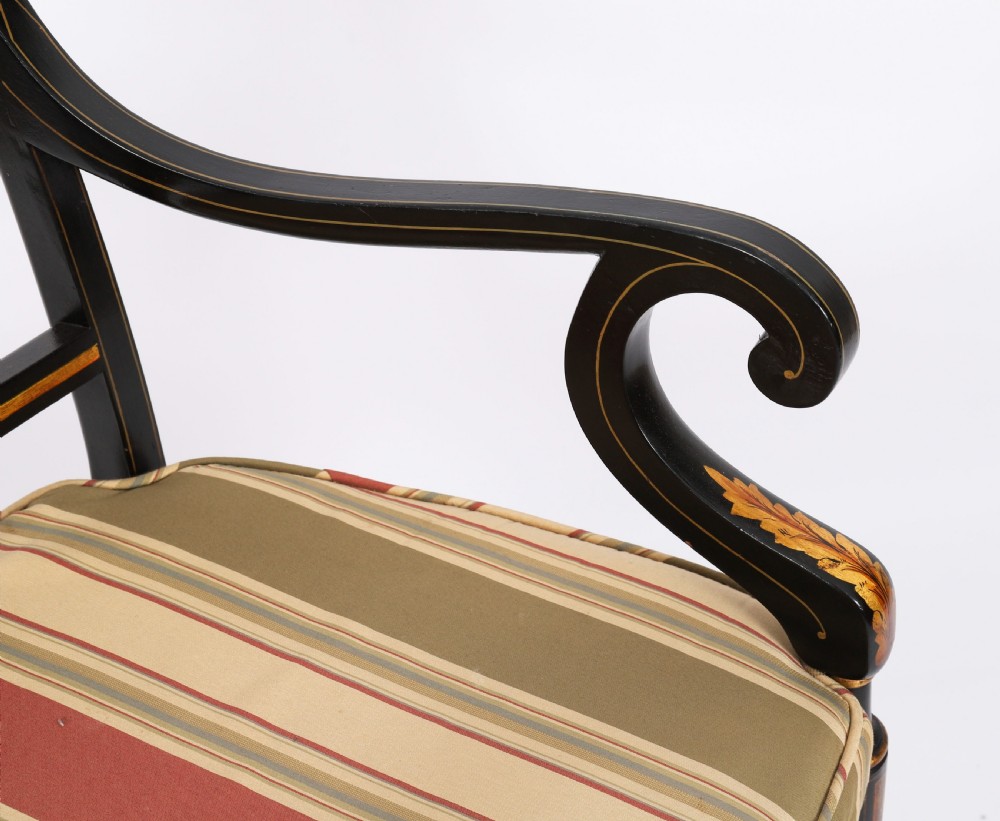 A set of ten ebonised and parcel-gilt Regency Revival dining chairs featuring pierced splat backs and striped upholstered seats. View X