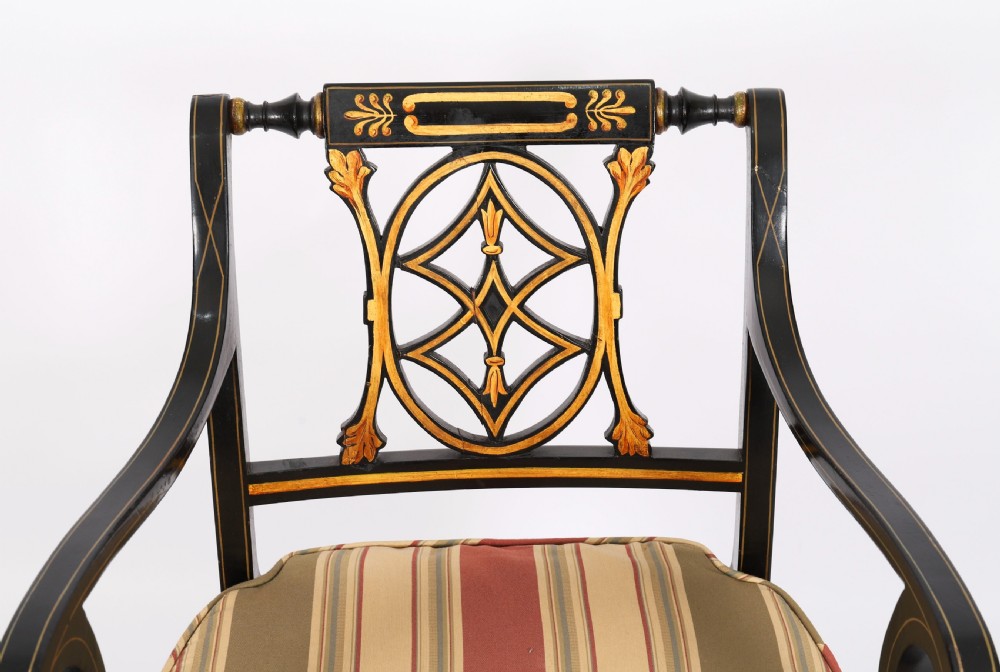 A set of ten ebonised and parcel-gilt Regency Revival dining chairs featuring pierced splat backs and striped upholstered seats. View XII