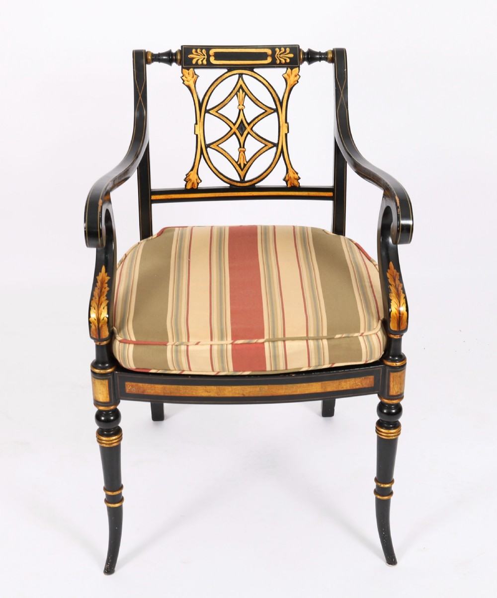 A set of ten ebonised and parcel-gilt Regency Revival dining chairs featuring pierced splat backs and striped upholstered seats. View XIV