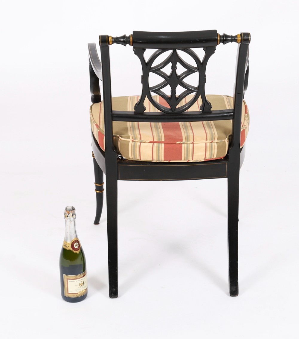A set of ten ebonised and parcel-gilt Regency Revival dining chairs featuring pierced splat backs and striped upholstered seats. View XV