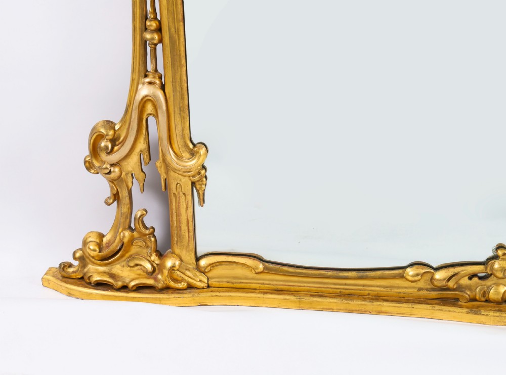 A large 19th-century Rococo Revival giltwood wall mirror featuring a carved frame with C-scrolls and asymmetrical cresting. View V