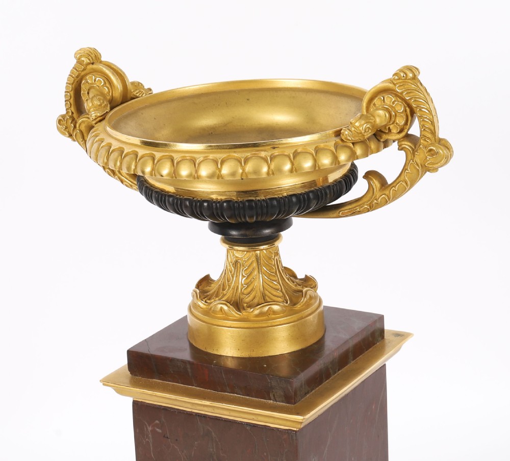 A pair of nineteenth-century French ormolu and bronze tazzas with scroll handles, mounted on tall rectangular red marble plinths. View II
