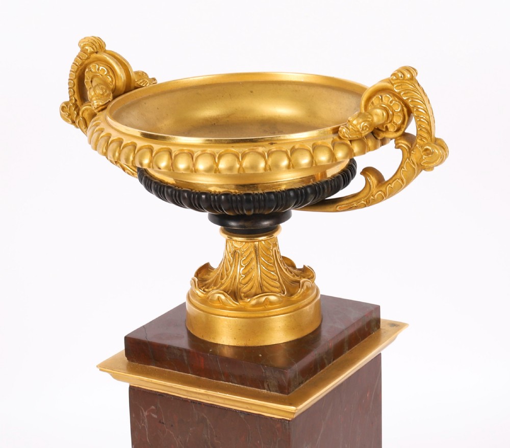 A pair of nineteenth-century French ormolu and bronze tazzas with scroll handles, mounted on tall rectangular red marble plinths. View IX