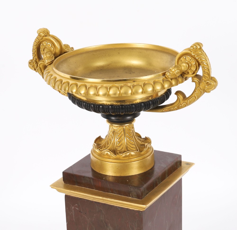 A pair of nineteenth-century French ormolu and bronze tazzas with scroll handles, mounted on tall rectangular red marble plinths. View X