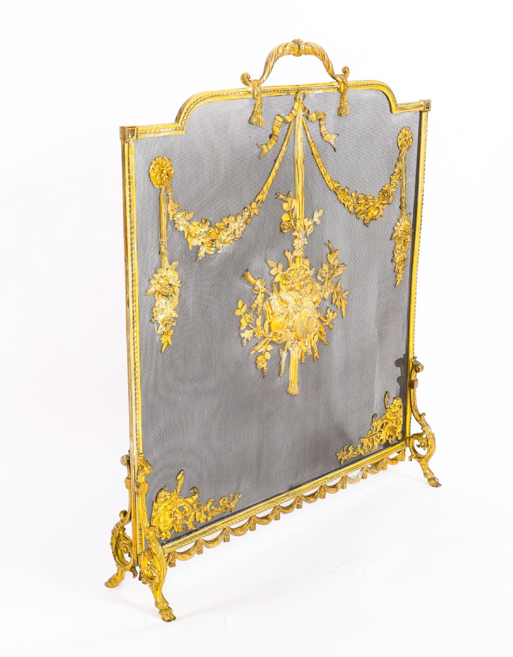 A 19th-century French gilt bronze fire screen featuring a woven mesh panel decorated with central musical trophy motifs, floral garlands, and ribbon swags. View IV