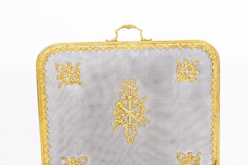 A 19th-century French Empire Revival gilt bronze fire screen featuring fine wire mesh adorned with cast classical trophy mounts, a top handle, and scrolled feet. View III
