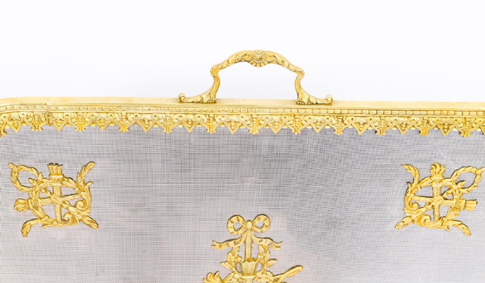 A 19th-century French Empire Revival gilt bronze fire screen featuring fine wire mesh adorned with cast classical trophy mounts, a top handle, and scrolled feet. View VIII