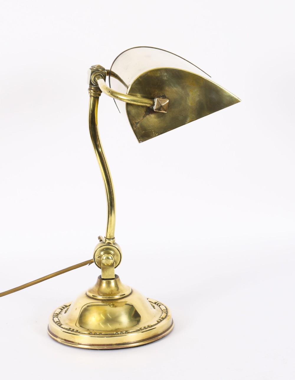 An Art Deco articulated brass desk lamp featuring a curved adjustable arm, a rectangular brass shade, and a moulded circular base. View VIII