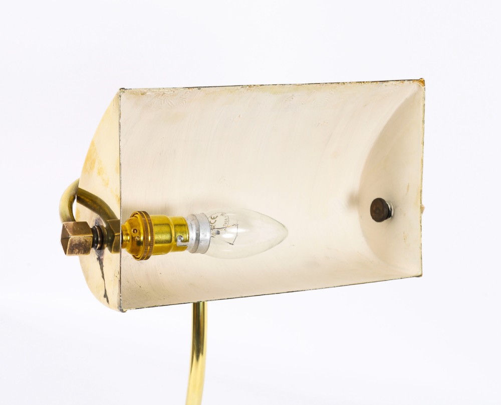 An Art Deco articulated brass desk lamp featuring a curved adjustable arm, a rectangular brass shade, and a moulded circular base. View IX