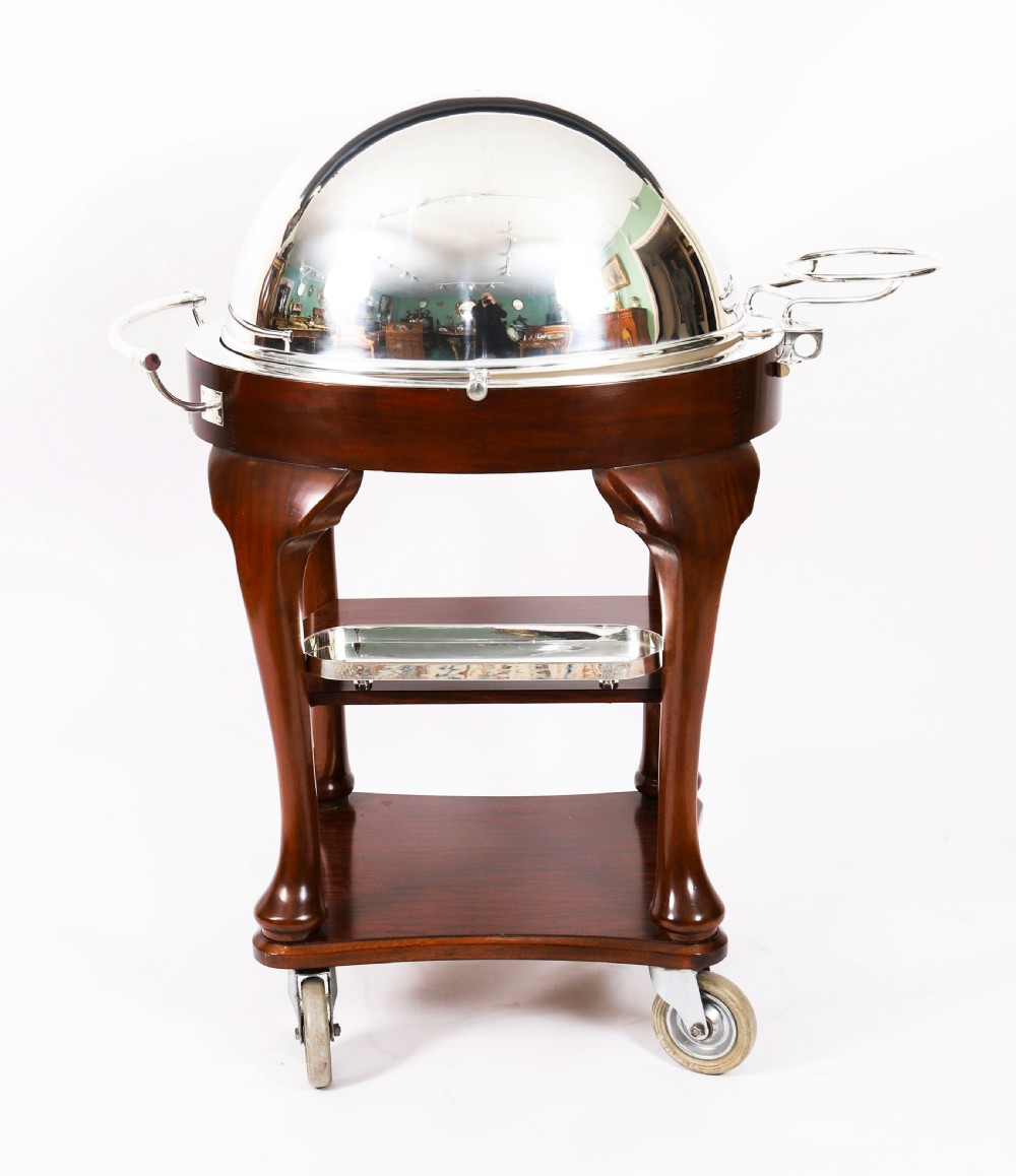 An Art Deco silver-plated beef carving trolley with a hemispherical revolving dome cover mounted on a dark mahogany frame with cabriole legs. View II