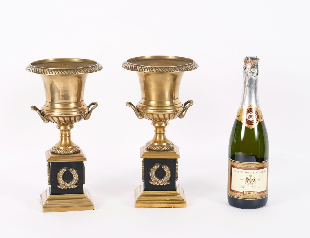 A pair of 19th-century Neoclassical brass Grand Tour campana urns mounted on square black plinths with gilded laurel wreath embellishments. View XVI