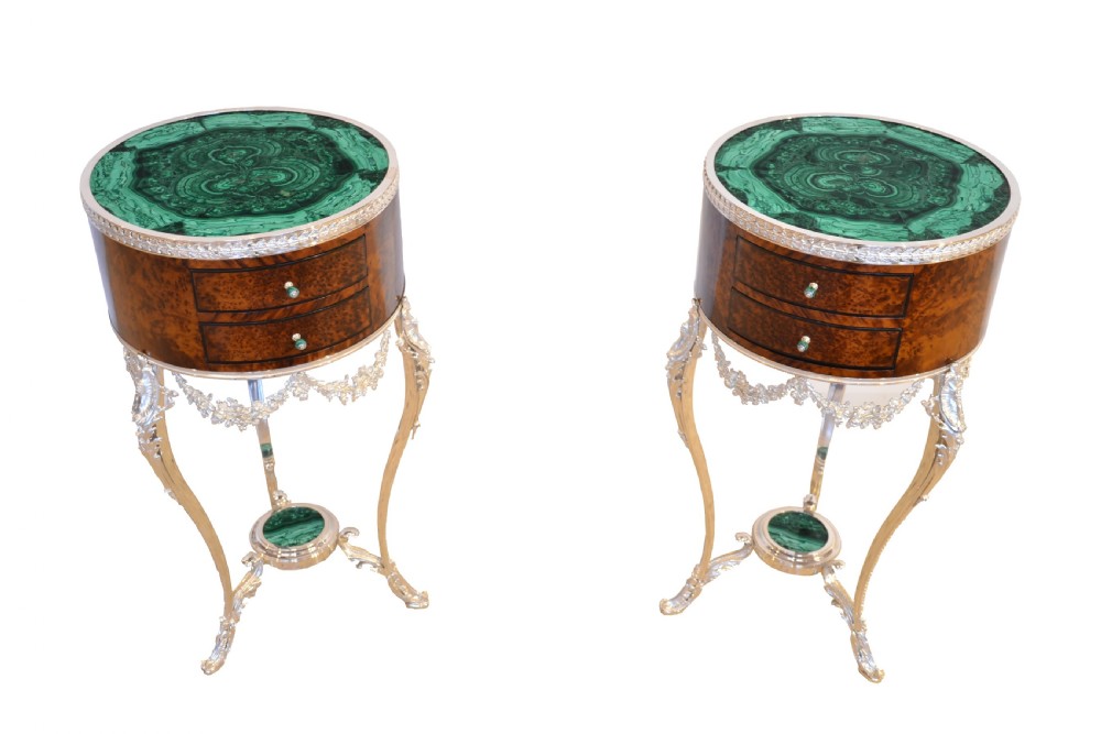 A pair of circular French occasional tables featuring rich brown thuya wood bodies with drawers, green malachite tops, and silvered bronze cabriole legs.
