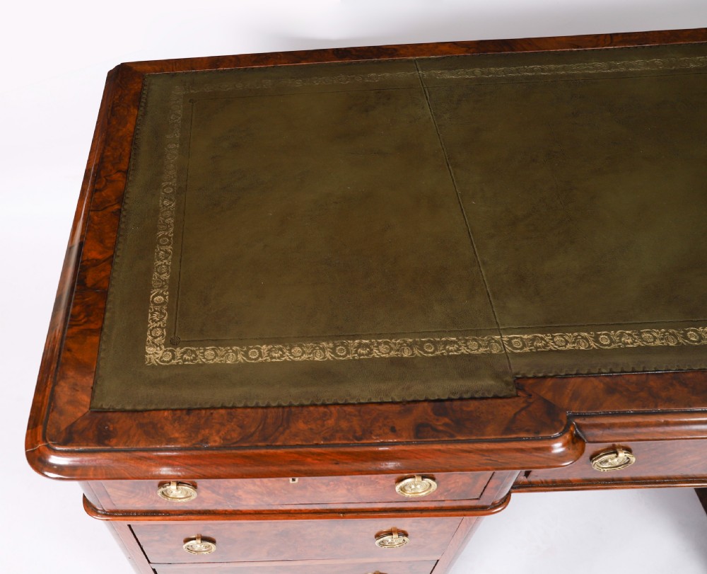 A nineteenth-century Victorian burr walnut twin pedestal desk featuring a green leather writing insert, brass ring handles, and multiple drawers. View IV