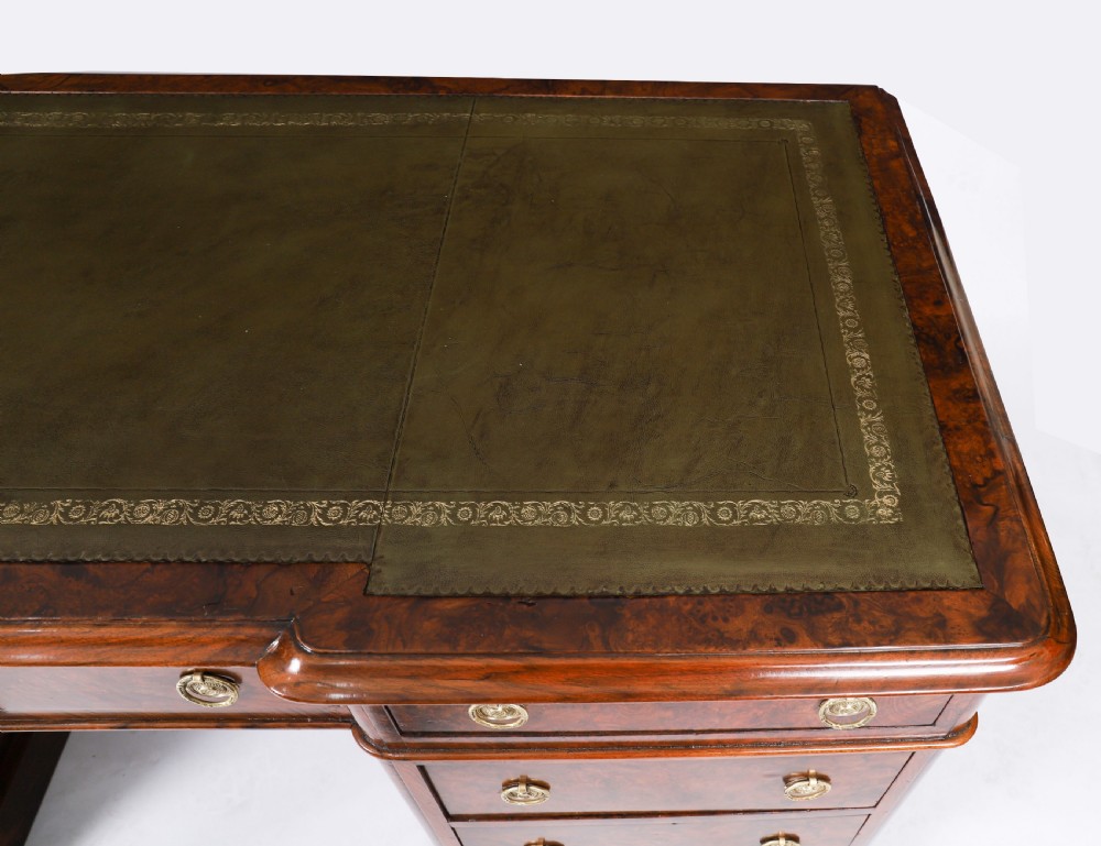 A nineteenth-century Victorian burr walnut twin pedestal desk featuring a green leather writing insert, brass ring handles, and multiple drawers. View V