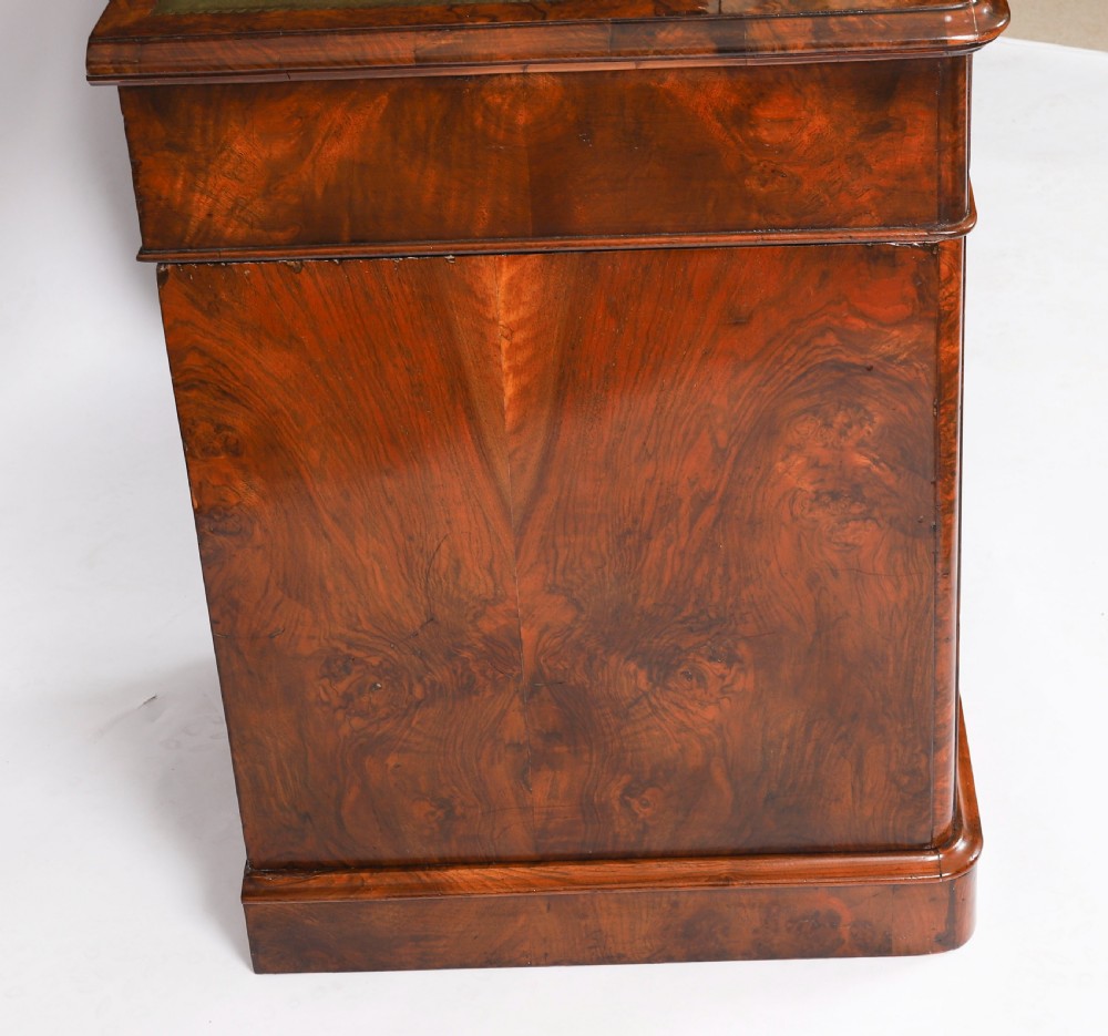 A nineteenth-century Victorian burr walnut twin pedestal desk featuring a green leather writing insert, brass ring handles, and multiple drawers. View XVIII