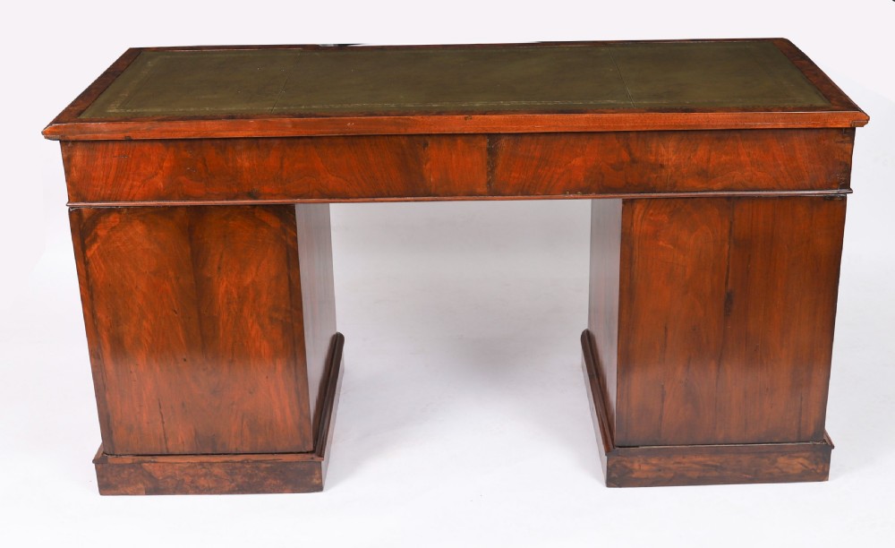 A nineteenth-century Victorian burr walnut twin pedestal desk featuring a green leather writing insert, brass ring handles, and multiple drawers. View XIX