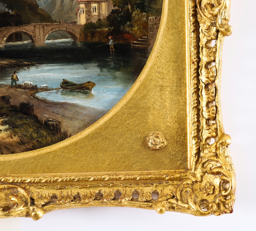 A pair of nineteenth-century oil paintings on board depicting river scenes with figures and ruins, housed in square gilded frames with circular tondo apertures. View XV