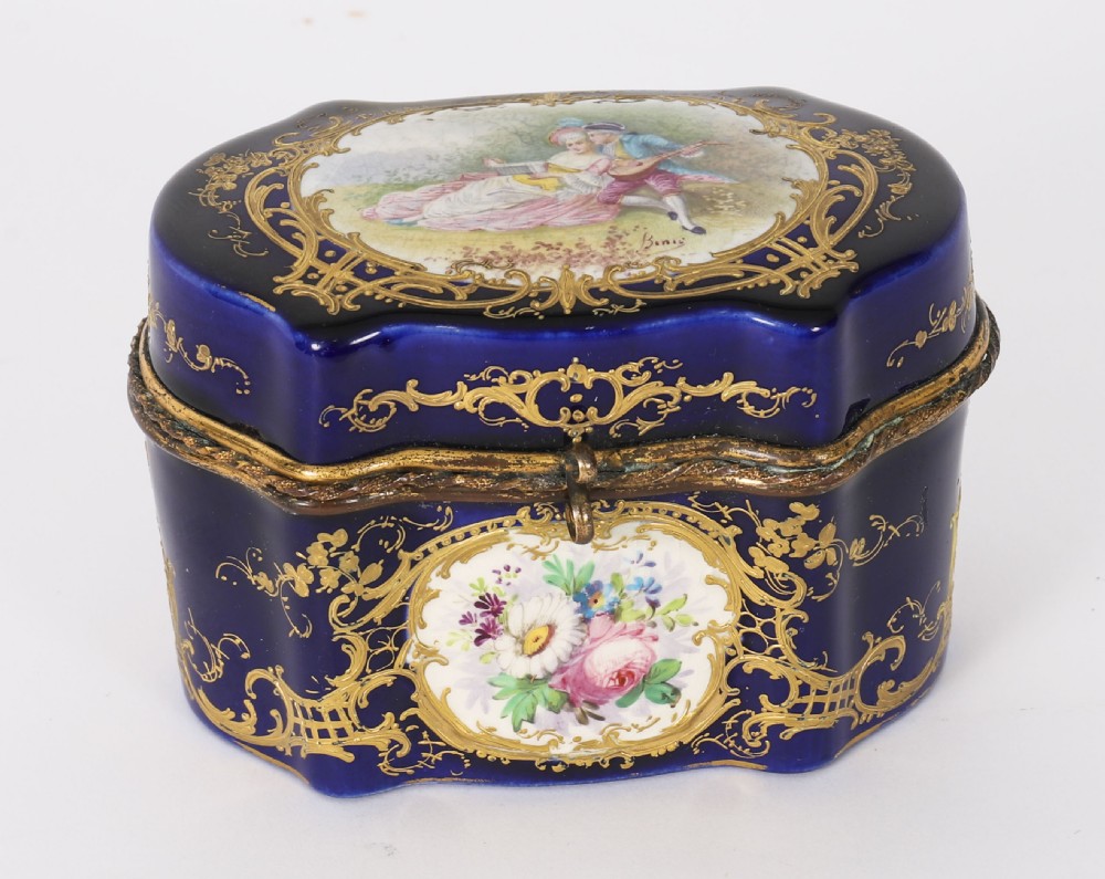 A serpentine cobalt blue porcelain casket featuring gilt-bronze mounts, hand-painted romantic scenes, floral reserves, and heavy gold scrollwork. View II