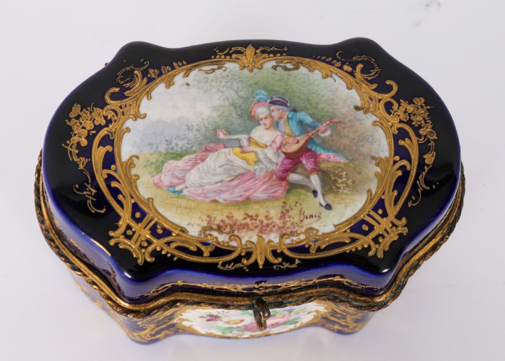 A serpentine cobalt blue porcelain casket featuring gilt-bronze mounts, hand-painted romantic scenes, floral reserves, and heavy gold scrollwork. View III