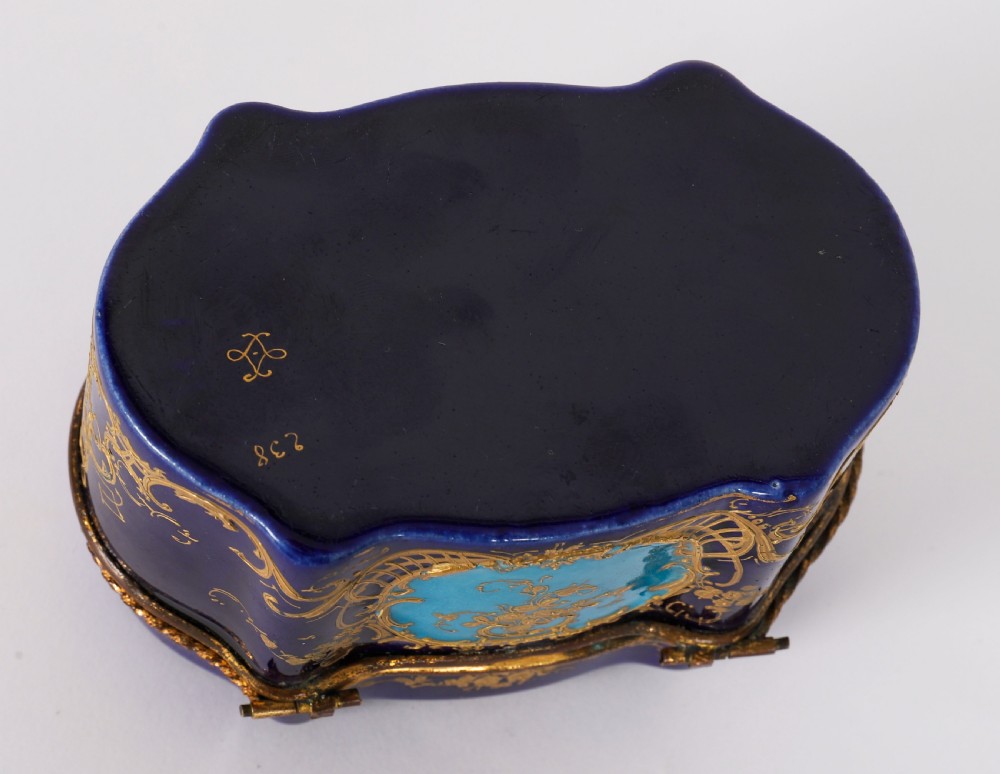 A serpentine cobalt blue porcelain casket featuring gilt-bronze mounts, hand-painted romantic scenes, floral reserves, and heavy gold scrollwork. View XII