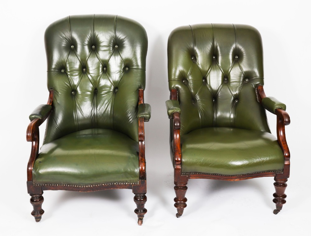 A pair of Victorian 19th-century armchairs upholstered in deep-buttoned green leather with dark mahogany frames and turned front legs on castors. View II