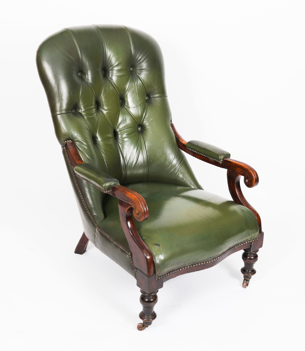 A pair of Victorian 19th-century armchairs upholstered in deep-buttoned green leather with dark mahogany frames and turned front legs on castors. View III
