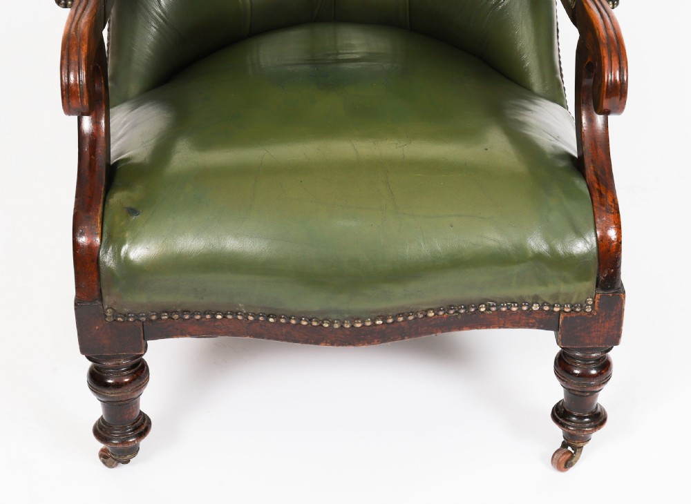 A pair of Victorian 19th-century armchairs upholstered in deep-buttoned green leather with dark mahogany frames and turned front legs on castors. View VIII