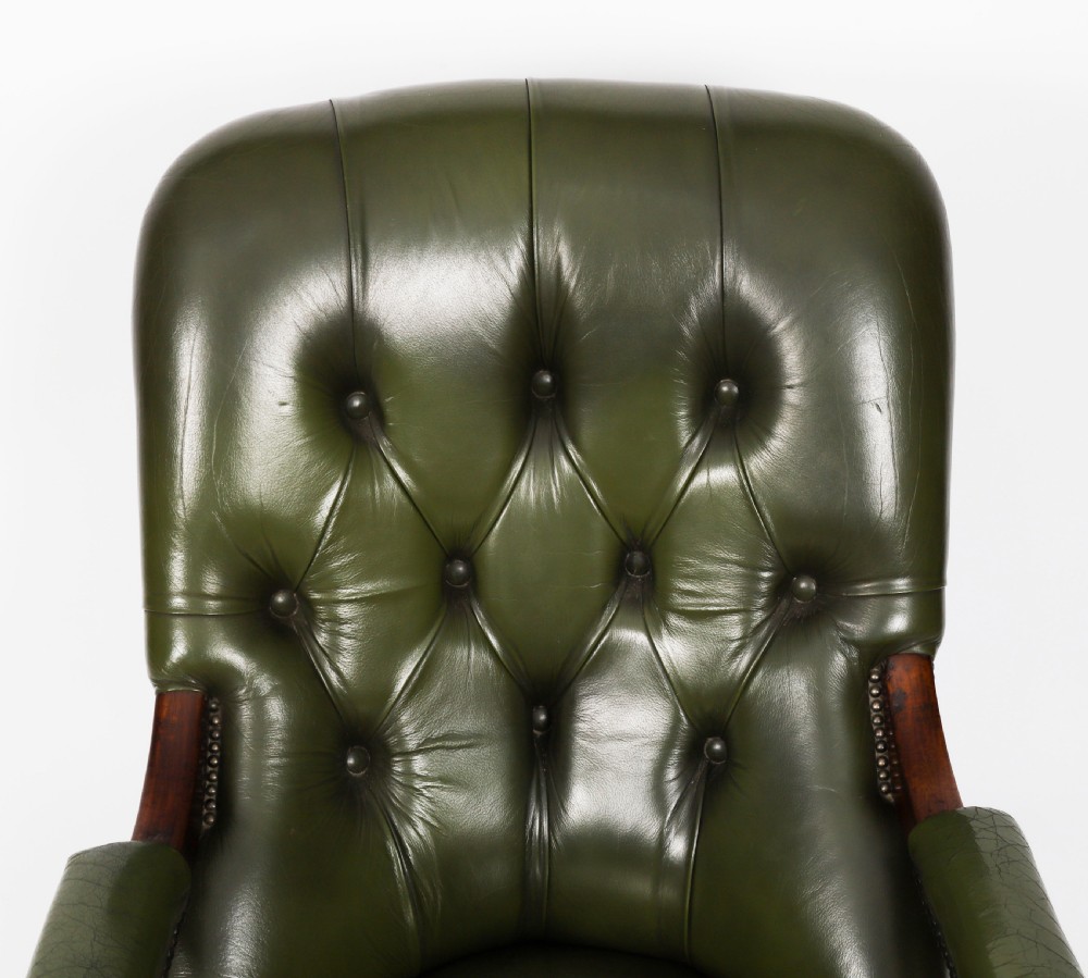 A pair of Victorian 19th-century armchairs upholstered in deep-buttoned green leather with dark mahogany frames and turned front legs on castors. View XIII