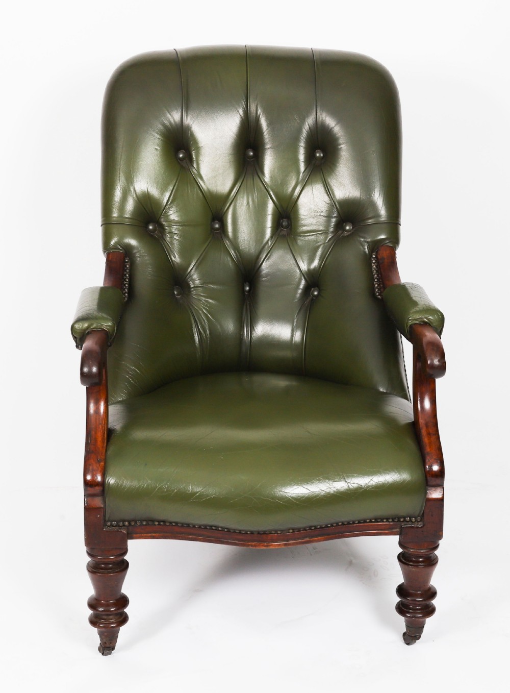 A pair of Victorian 19th-century armchairs upholstered in deep-buttoned green leather with dark mahogany frames and turned front legs on castors. View XIX