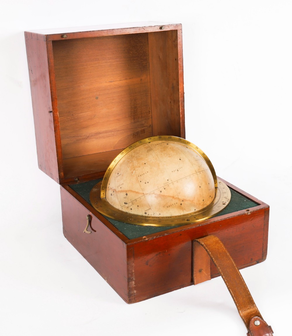 An open mahogany transit box displaying a 19th-century Paget star celestial globe with calibrated brass rings set over green felt lining.