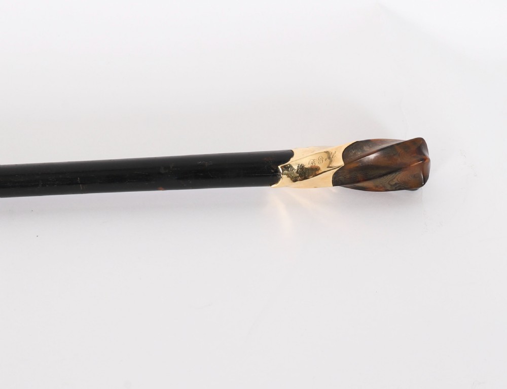 Late 19th-century walking stick featuring a carved spiral horn pommel above an engraved 18ct gold band on a dark wood shaft. View V
