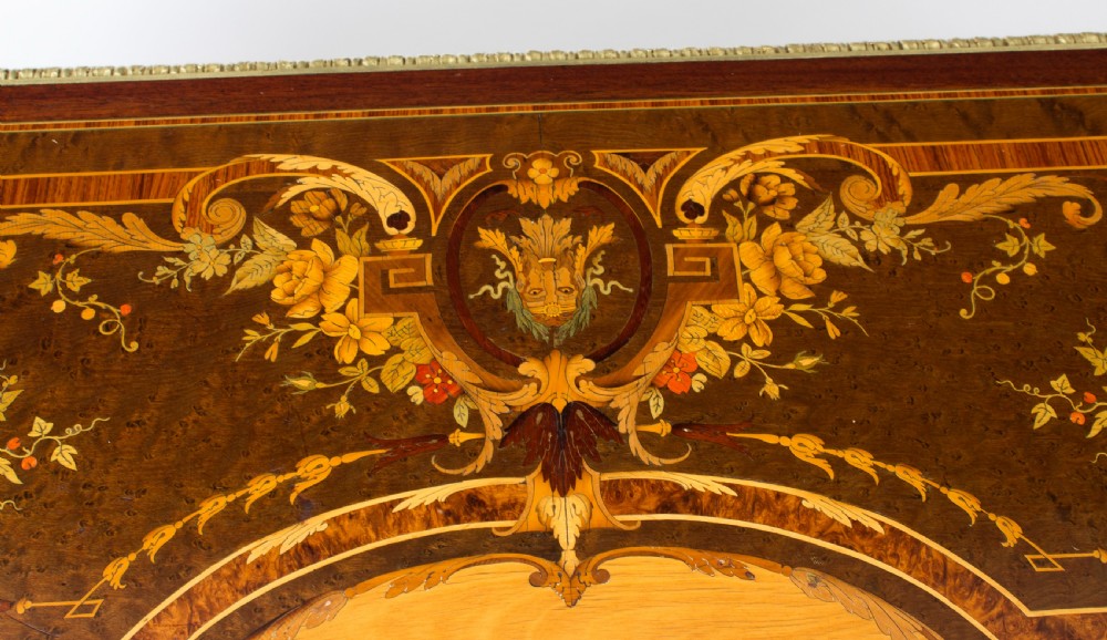 An antique French bureau plat writing table featuring detailed floral marquetry inlays, decorative gilt-bronze ormolu mounts, turned legs, and an X-frame stretcher. View IX