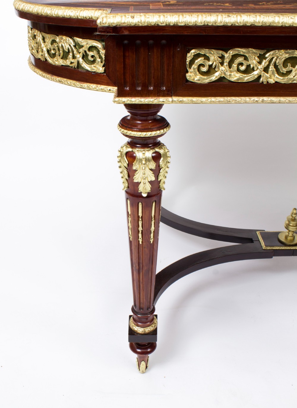 An antique French bureau plat writing table featuring detailed floral marquetry inlays, decorative gilt-bronze ormolu mounts, turned legs, and an X-frame stretcher. View XII