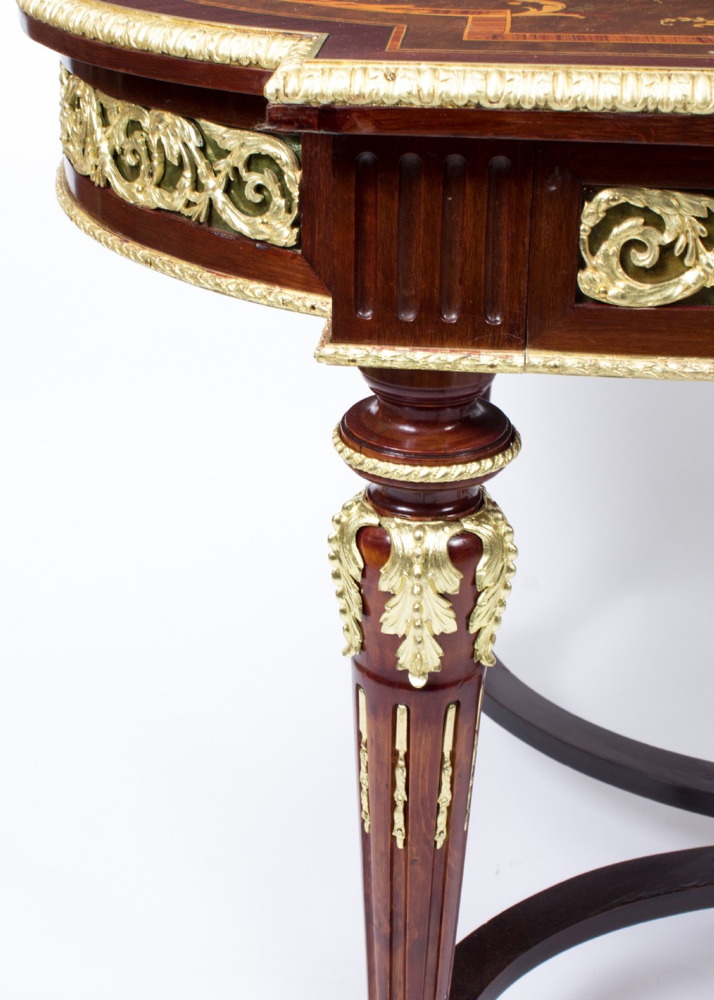 An antique French bureau plat writing table featuring detailed floral marquetry inlays, decorative gilt-bronze ormolu mounts, turned legs, and an X-frame stretcher. View XV