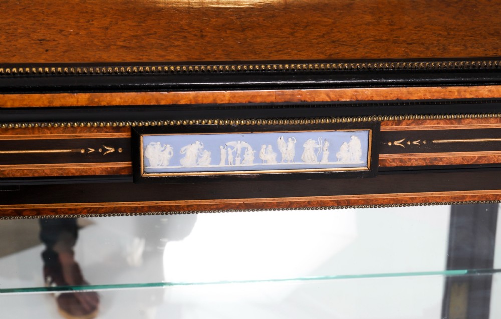 A Victorian ebonised and amboyna wood pier display cabinet featuring glass doors, interior glass shelves, and gilded brass mounts. View IV