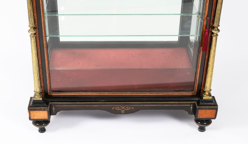 A Victorian ebonised and amboyna wood pier display cabinet featuring glass doors, interior glass shelves, and gilded brass mounts. View XI