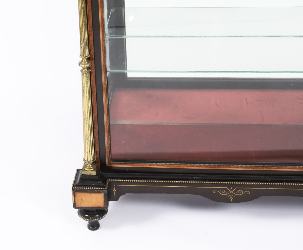 A Victorian ebonised and amboyna wood pier display cabinet featuring glass doors, interior glass shelves, and gilded brass mounts. View XIII
