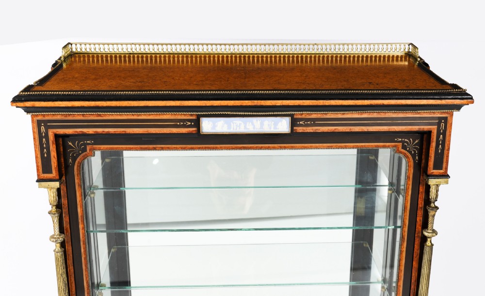 A Victorian ebonised and amboyna wood pier display cabinet featuring glass doors, interior glass shelves, and gilded brass mounts. View XIV