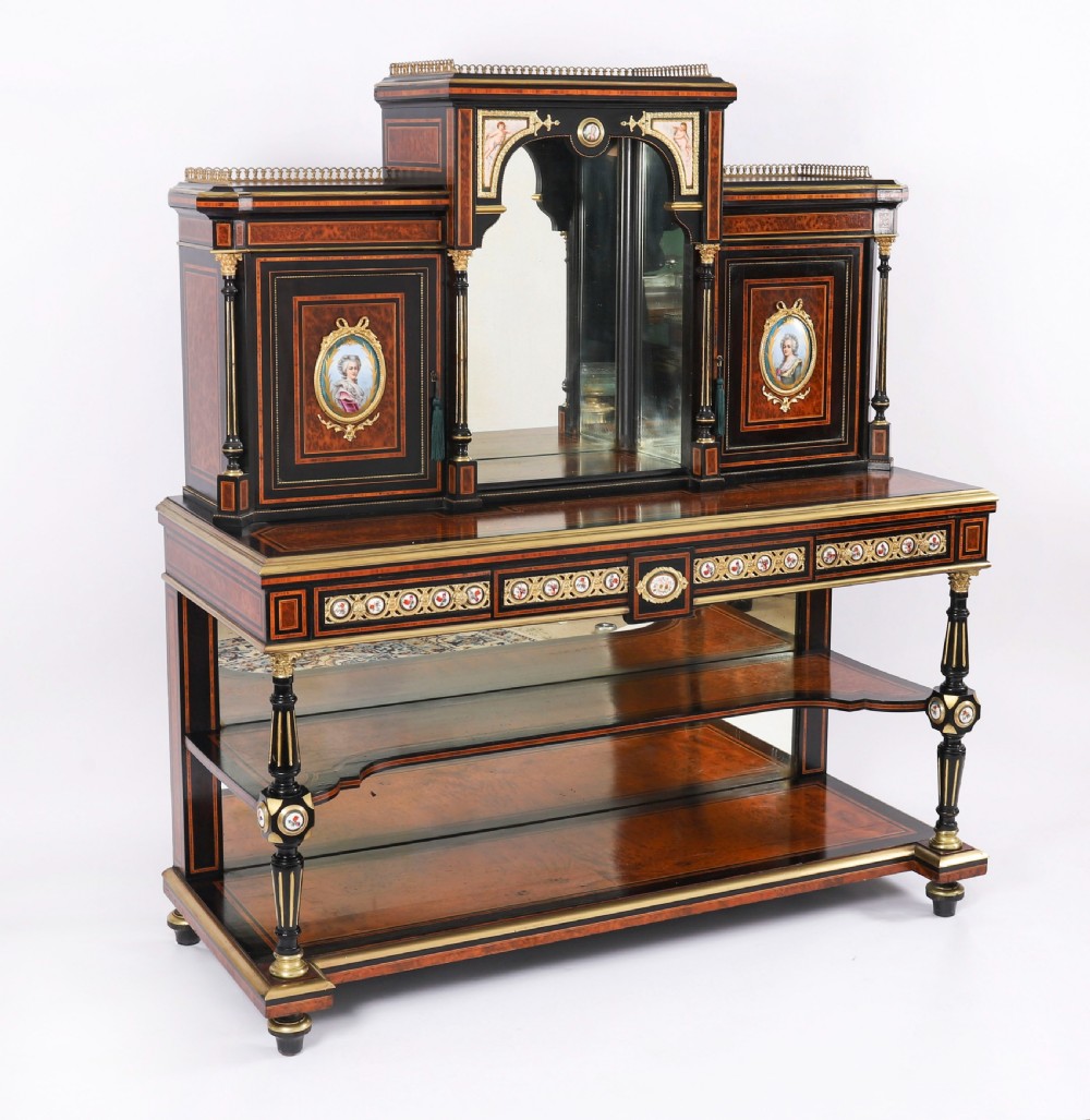 Victorian amboyna and ebonised bonheur du jour desk with porcelain portrait plaques, brass mounts, a central mirror, and an open lower shelf.