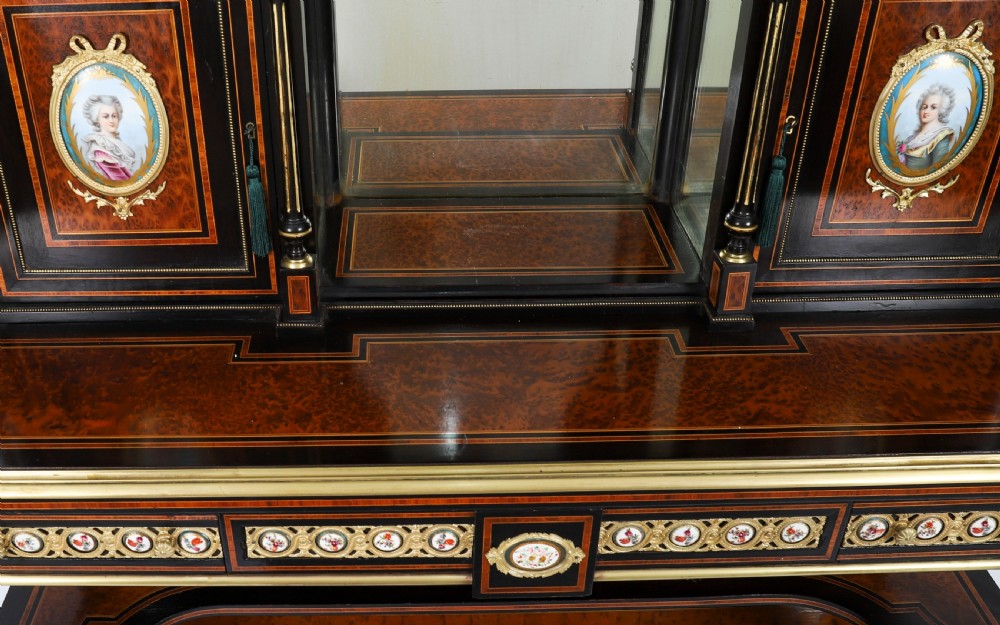 Victorian amboyna and ebonised bonheur du jour desk with porcelain portrait plaques, brass mounts, a central mirror, and an open lower shelf. View IV