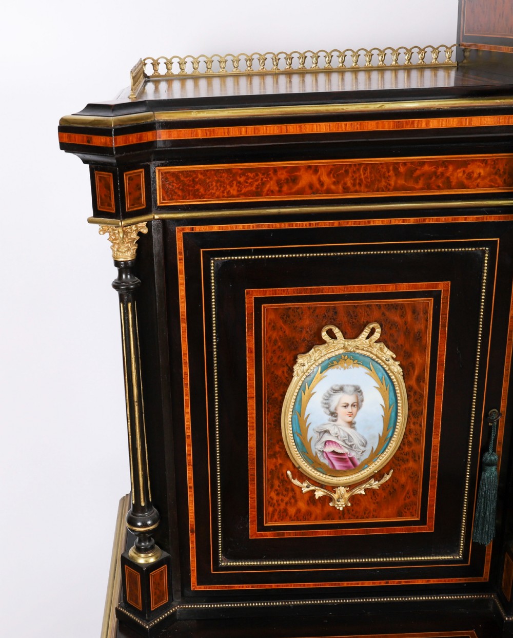 Victorian amboyna and ebonised bonheur du jour desk with porcelain portrait plaques, brass mounts, a central mirror, and an open lower shelf. View V
