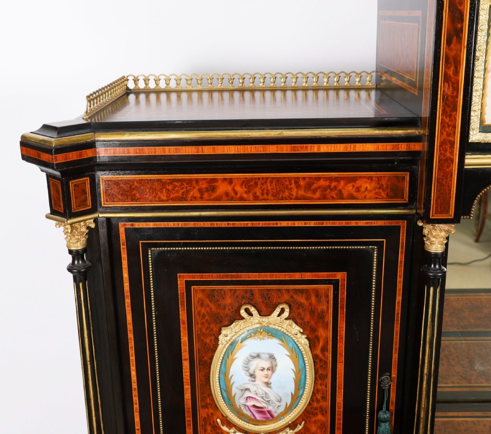 Victorian amboyna and ebonised bonheur du jour desk with porcelain portrait plaques, brass mounts, a central mirror, and an open lower shelf. View VI