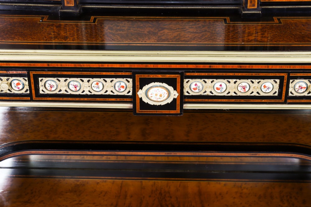 Victorian amboyna and ebonised bonheur du jour desk with porcelain portrait plaques, brass mounts, a central mirror, and an open lower shelf. View XII