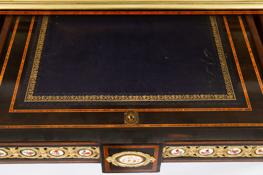 Victorian amboyna and ebonised bonheur du jour desk with porcelain portrait plaques, brass mounts, a central mirror, and an open lower shelf. View XIV