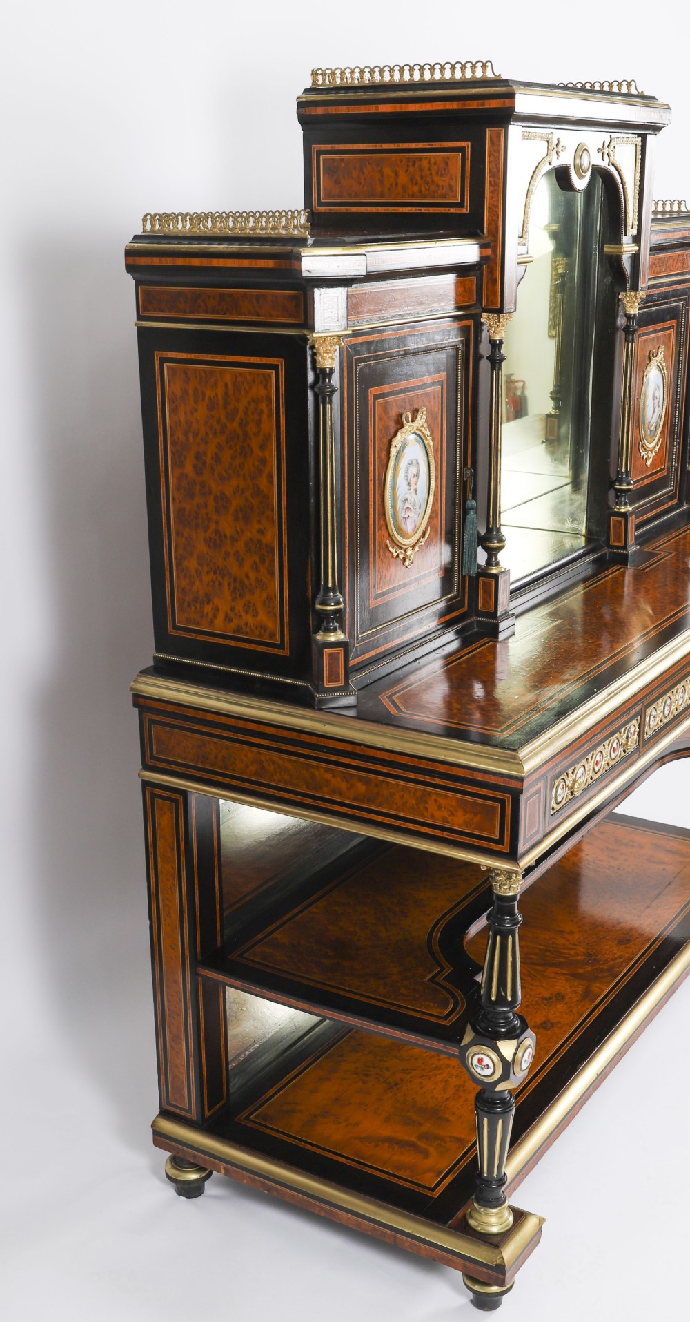 Victorian amboyna and ebonised bonheur du jour desk with porcelain portrait plaques, brass mounts, a central mirror, and an open lower shelf. View XIX